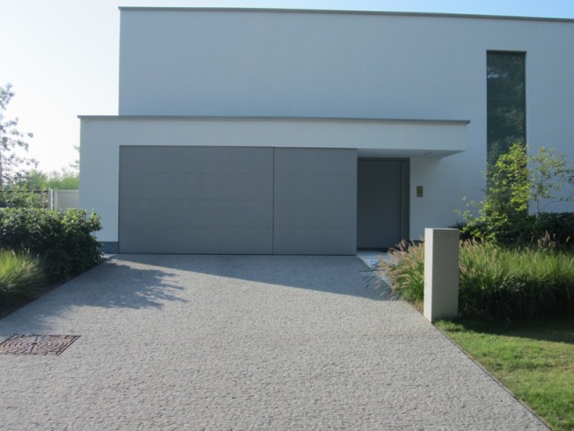ALUMINIUM COLLECTION : Visual sectional door integrated in the facade cladding and matching front door