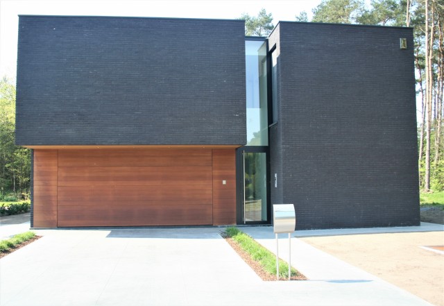WOOD Collection : habillage de façade en bois massif Planchette horizontale avec porte sectionnelle et finitions latérales et au-dessus de la porte